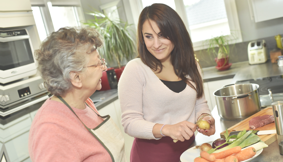 caregiver and senior woman talking in the kitchen